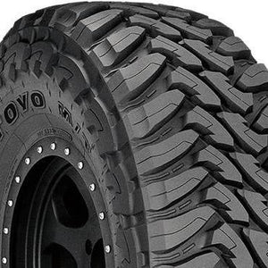 Angled view of Toyo Open Country M/T 295/65R20 LT P mud-terrain tire showing deep tread blocks and rugged off-road design.
